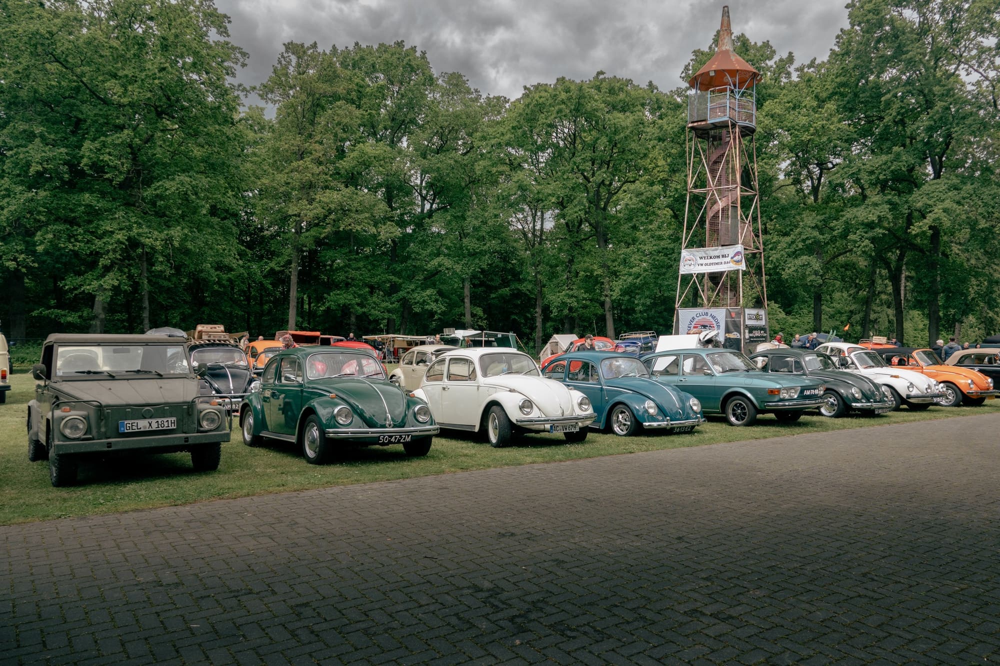 Aircooled Volkswagens parked together, people between them.
